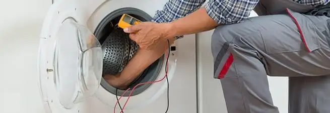 Dryer repair technician inspecting and repairing a clothes dryer in New Haven, CT