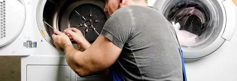 Dryer repair technician fixing a clothes dryer drum in New Haven, CT