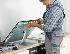 Appliance repair technician installing a built-in cooktop in New Haven, CT