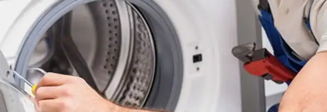 Appliance technician repairing a clothes dryer drum and internal parts in New Haven, CT