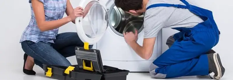 Washer repair technician inspecting a front-load washing machine with tools in New Haven, CT