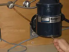 Garbage disposal repair technician tightening the mounting ring under a sink in New Haven, CT