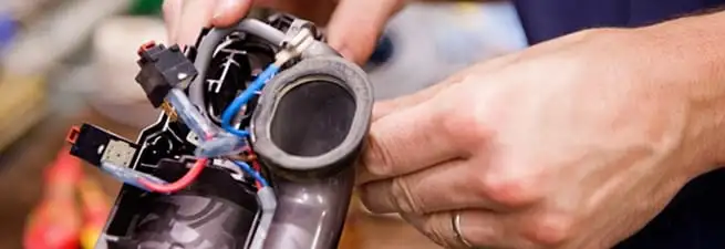 Vacuum repair technician reconnecting wiring and components in New Haven, CT