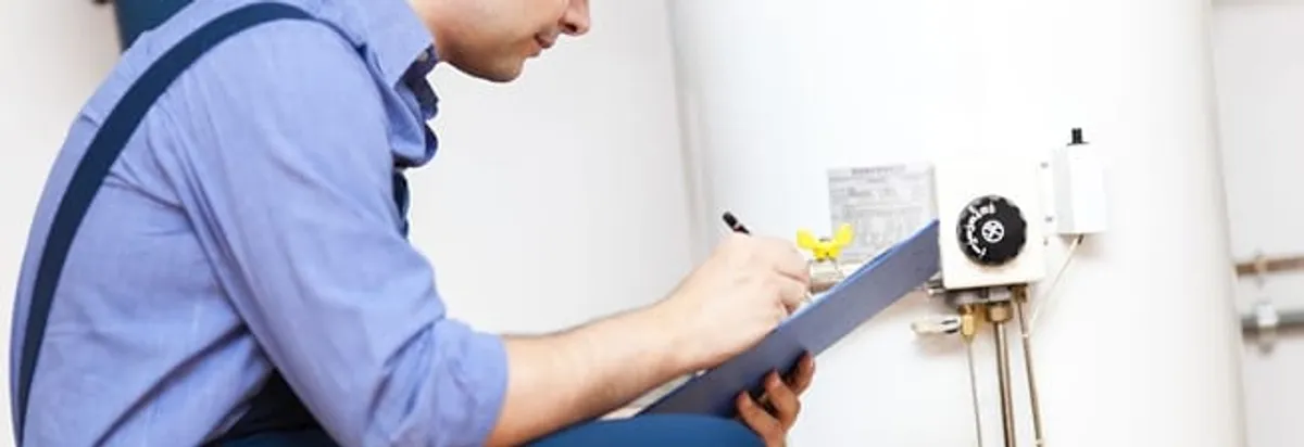 Water heater repair technician inspecting the unit and recording service notes in New Haven, CT