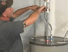 Water heater repair technician tightening supply line connections in New Haven, CT
